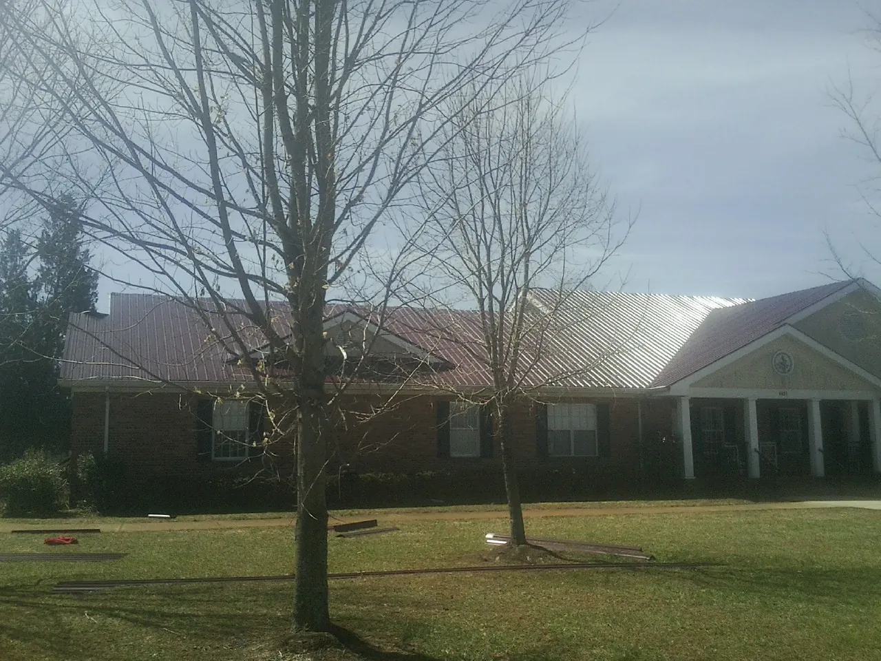 Red metal roof on a brick building seen from the front lawn in Saint Helena