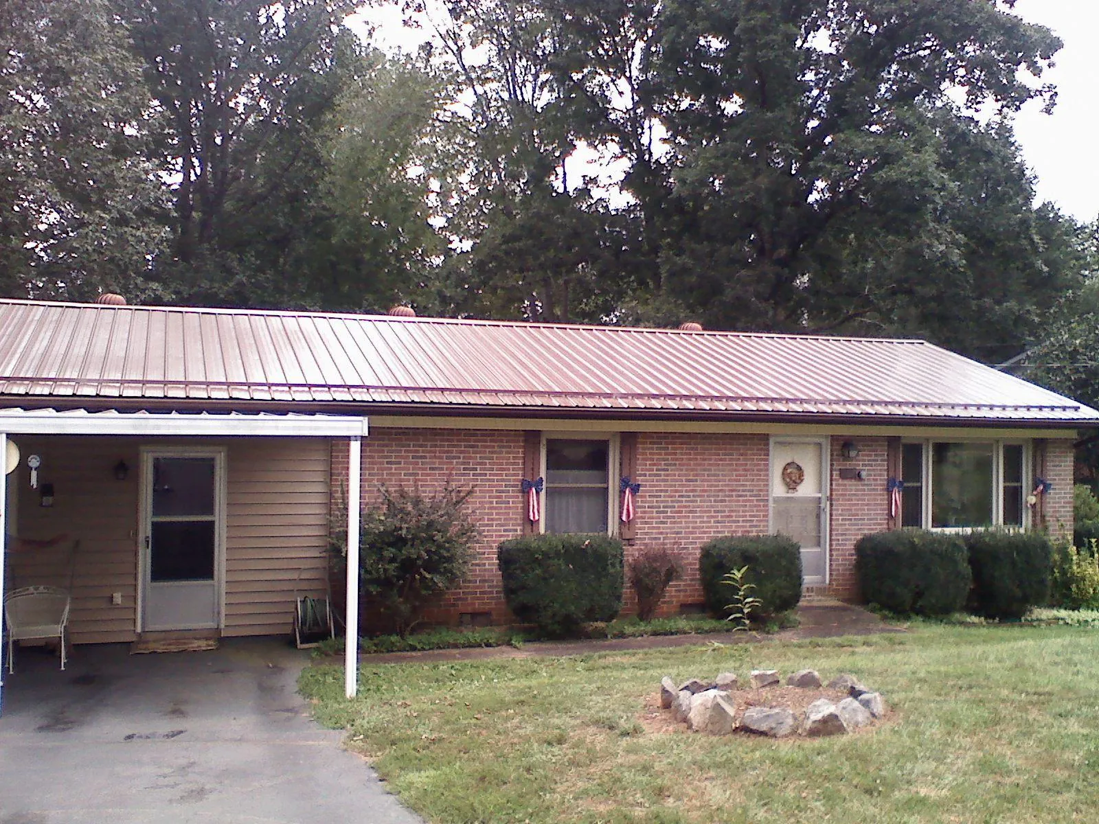 Bronze metal roof and carport on a brick ranch home — Roof Repair work by our crew in Saint Helena